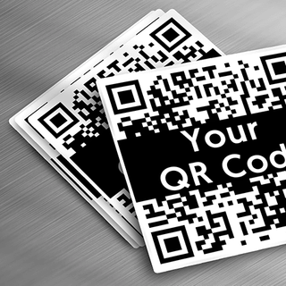 Custom vinyl QR code stickers spread out on metal table.